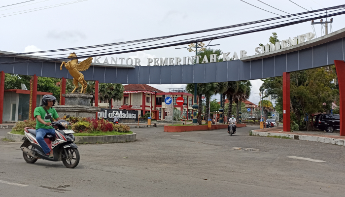 MELINTAS: Seorang pengendara roda dua sedang melintas di area pintu masuk Kantor Pemkab Sumenep.(FOTO: Hayat/Warta9.co.id)