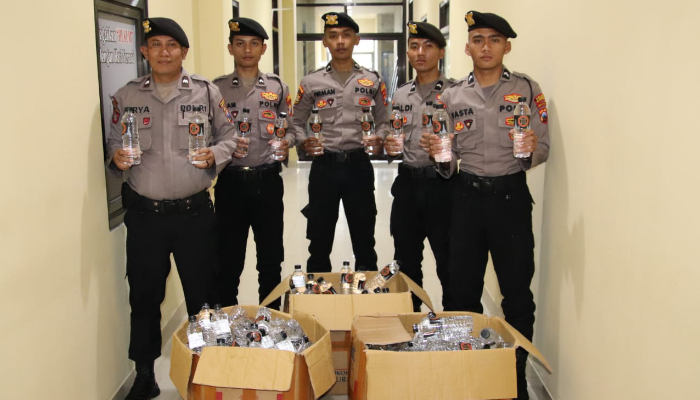 Aparat Kepolisian saat menunjukkan barang bakti ratusan botol arak Bali. (Foto: Dok. Warta9)